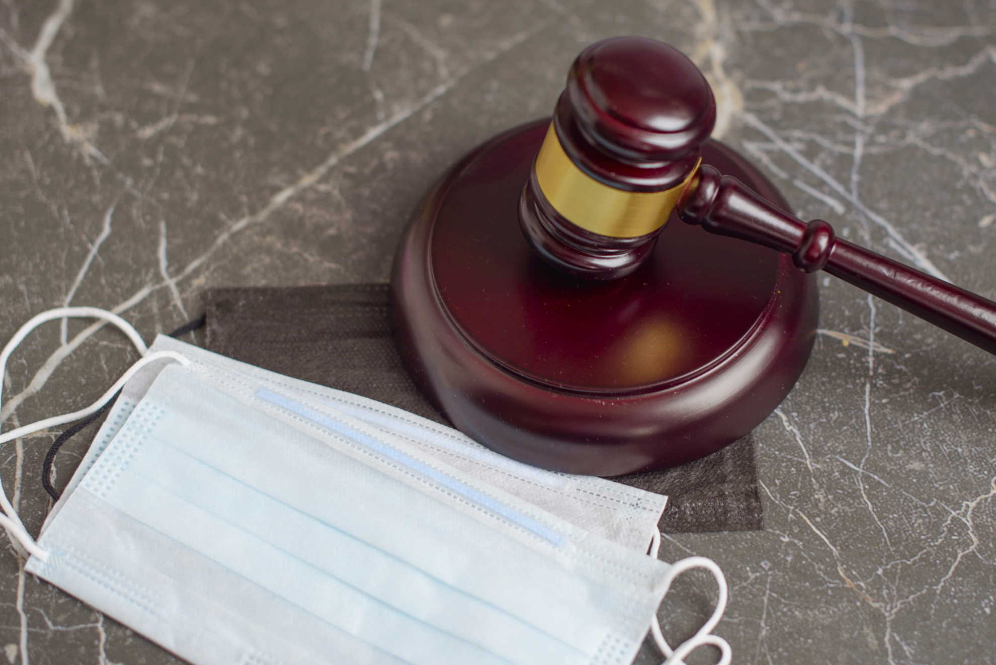 brown gavel and medical protective masks on marble background